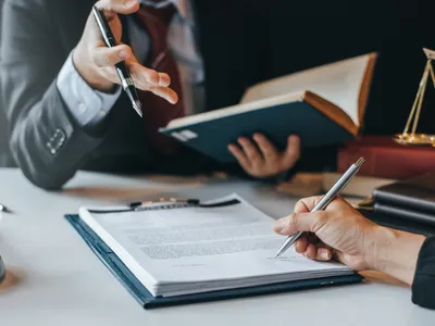 Lawyers holding books, documents, pens in discussion