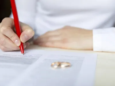 Signing divorce papers wedding ring in foreground